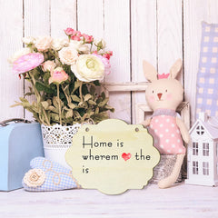 Decorative scene with a rabbit plush toy, flowers, and a sign on a wooden background