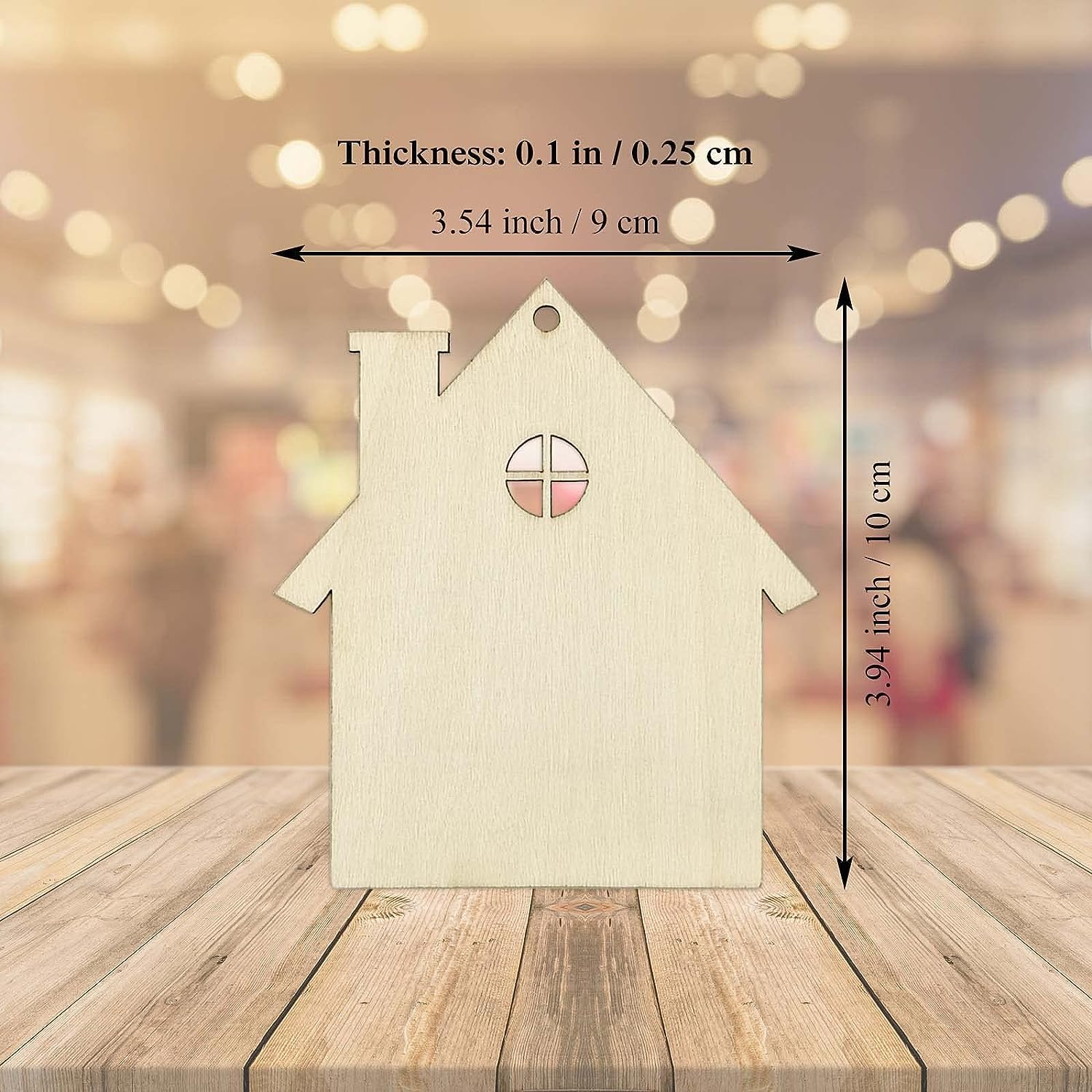 Wooden house-shaped ornament with measurements on a wooden surface and blurred background
