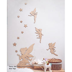 Wooden fairy and star wall decors on a white wall with a small basket and toy unicorn below.