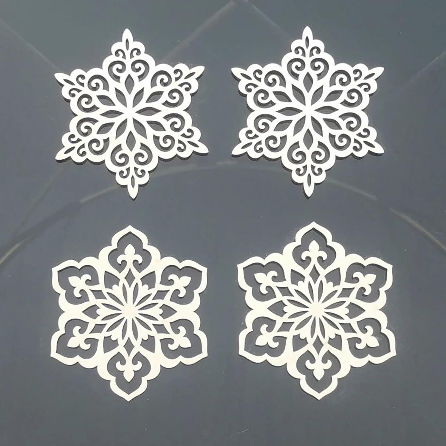 Four white snowflake-shaped cutouts on a dark background