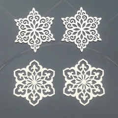 Four white snowflake-shaped cutouts on a dark background