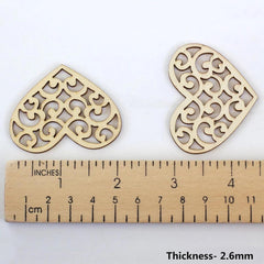 Two decorative wooden heart shapes with a ruler showing their thickness on a white background.