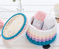 Colorful woven baskets with yarn on a white surface
