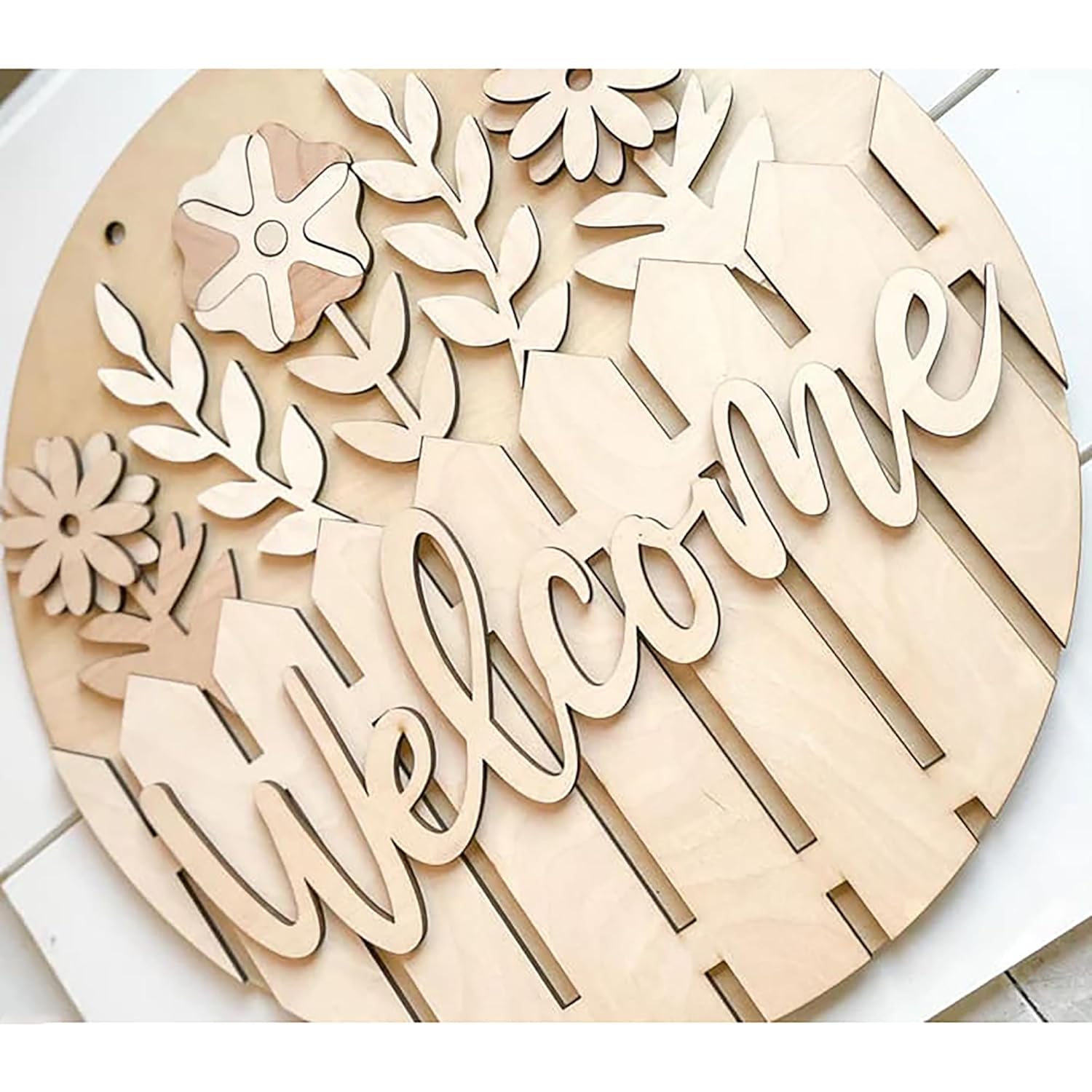 Wooden decorative sign with 'Welcome' and floral designs on a white background