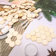 Hexagonal wooden coasters on a surface with a cup of hot chocolate and marshmallows.