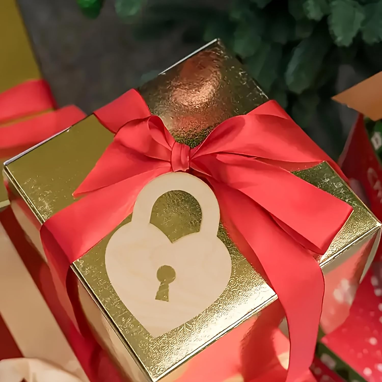 Gold gift box with red ribbon and lock design, surrounded by greenery