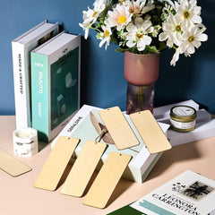 Gold bookmarks on a magazine with a vase of flowers and books in the background.