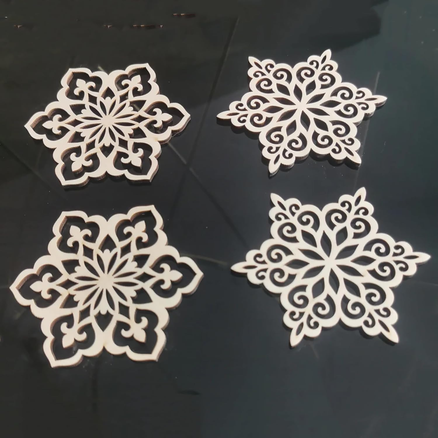 Four white snowflake-shaped cutouts on a black background