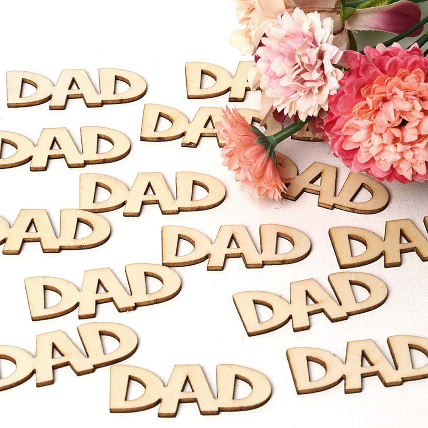 Wooden 'DAD' letters with pink flowers on a white background