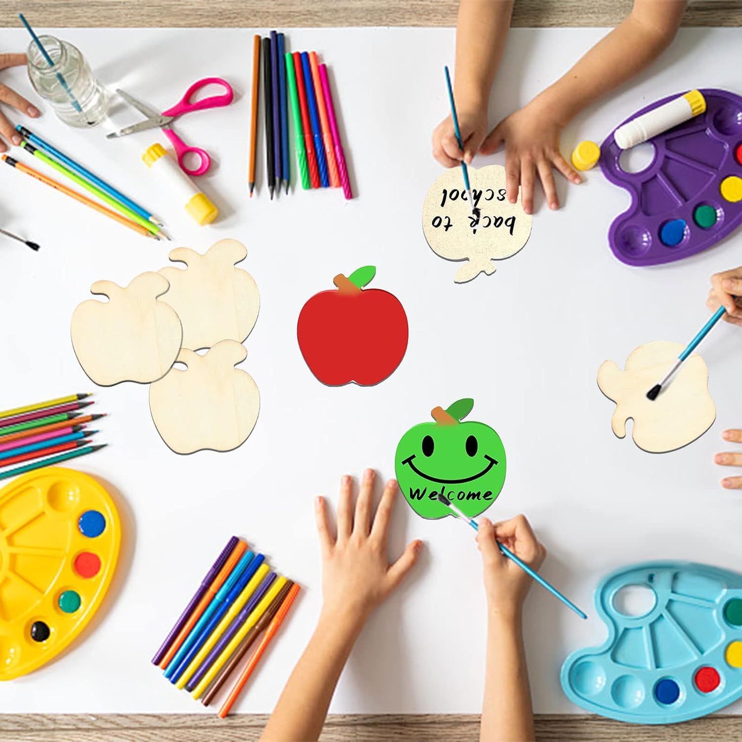 Children's hands coloring and crafting with art supplies on a table.