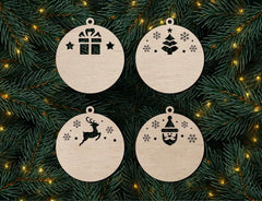 Four wooden Christmas ornaments with festive designs on a green branch background.
