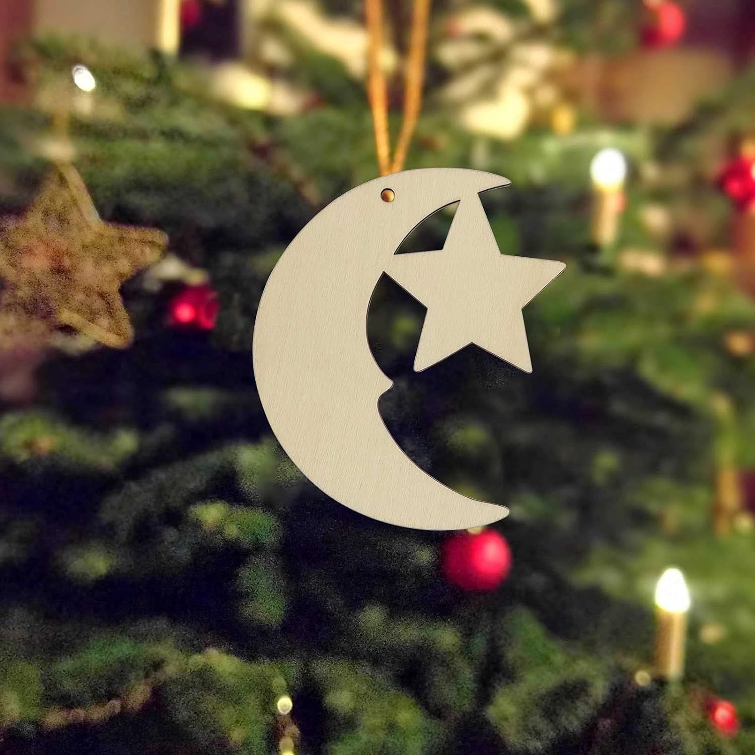 Decorative moon and star ornament on a Christmas tree.
