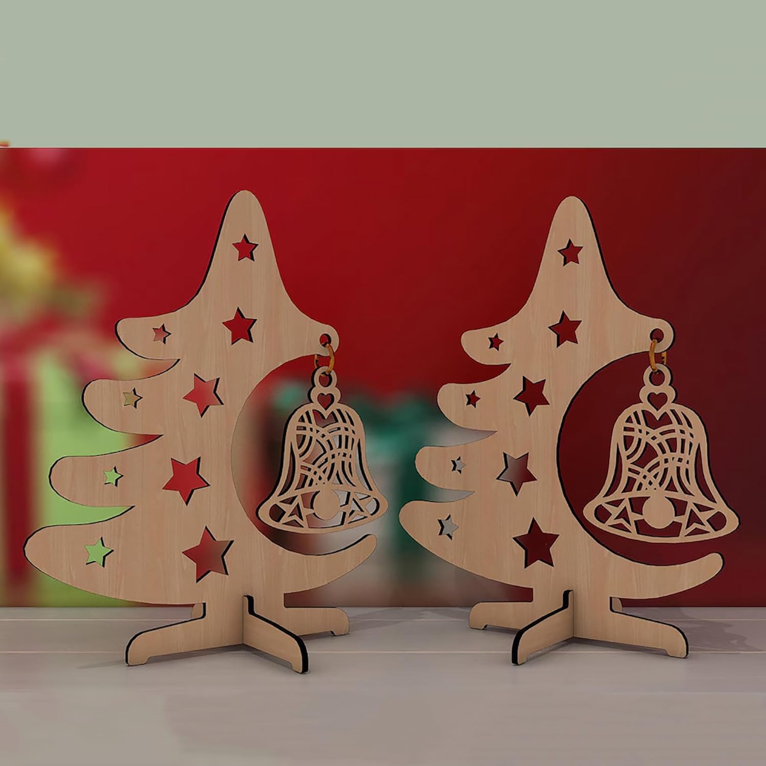 Two wooden Christmas tree decorations with bell ornaments on a red background