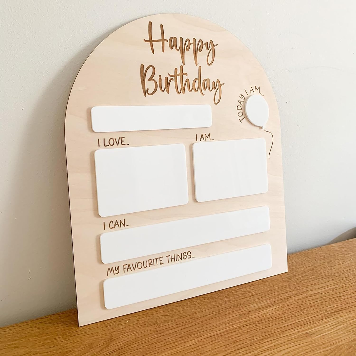 Wooden birthday card with blank sections for writing on a wooden surface.