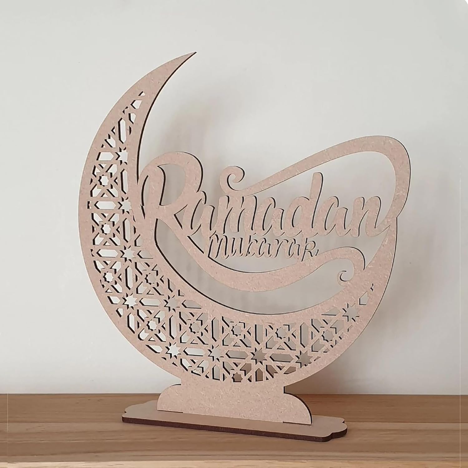 Wooden crescent moon decoration with 'Ramadan mubarak' text on a white background