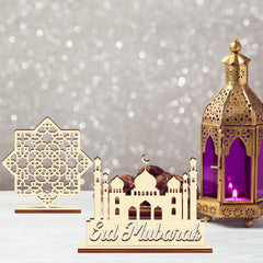 Decorative set with 'Eid Mubarak' card, miniature mosque model, and gold lantern on a gray background.