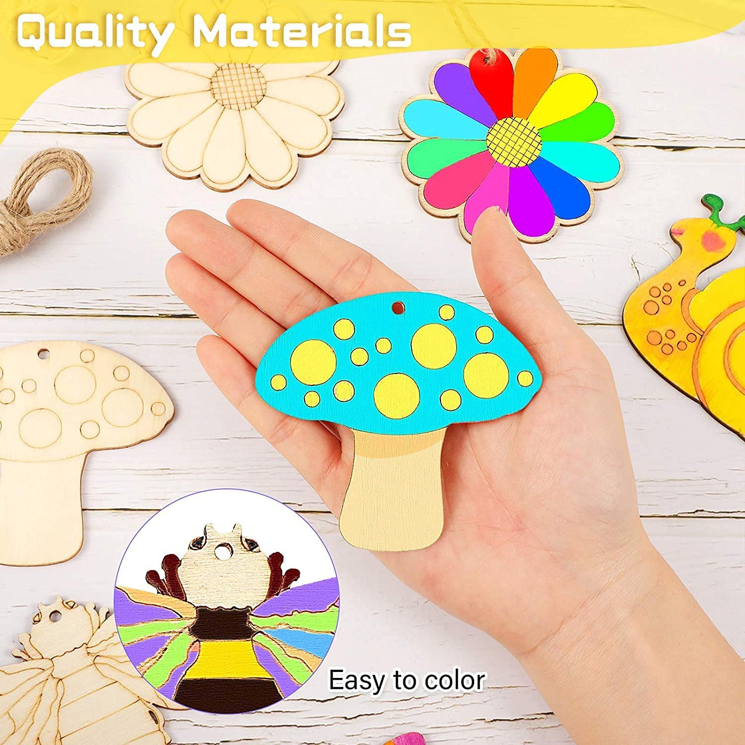 Hand holding a colorful wooden craft shaped like a mushroom with other crafts on a wooden surface.