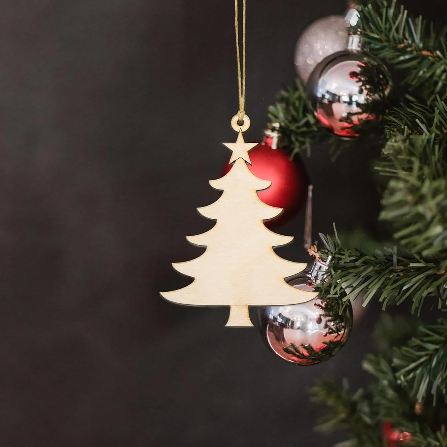 Christmas tree ornament hanging on a branch with dark background