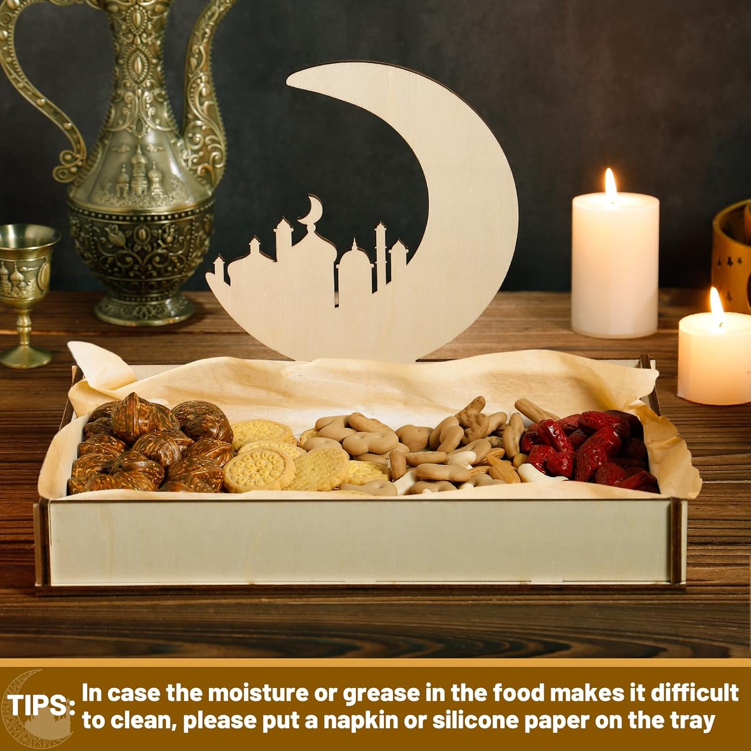 Decorative tray with food items, moon and mosque silhouette, candles, and ornate teapot on a dark background.