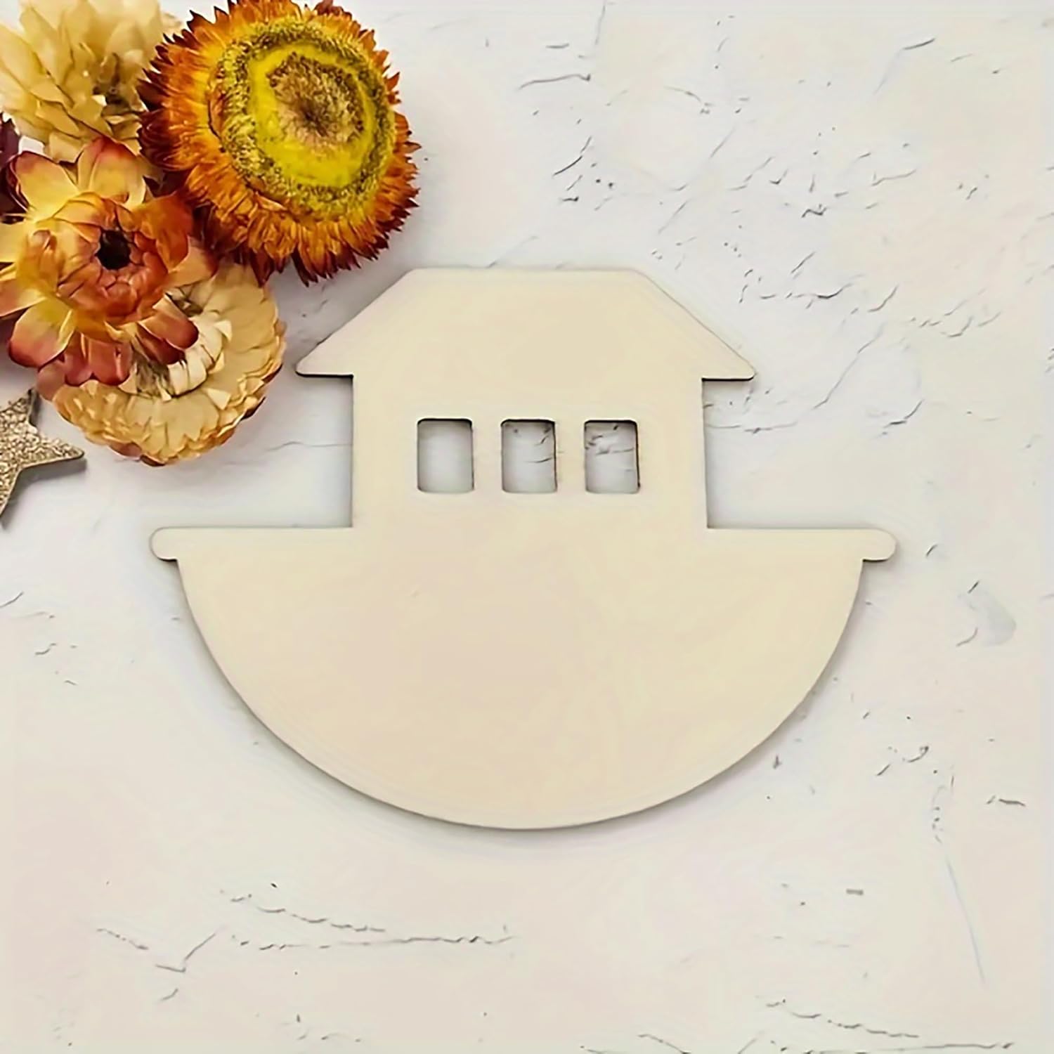 Wooden boat-shaped candle holder on a textured surface with flowers in the background