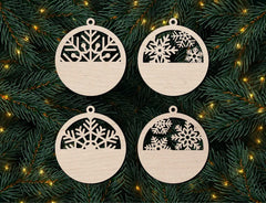 Four wooden Christmas ornaments with snowflake designs on a green branch background.