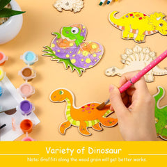 Colorful dinosaur-shaped wooden toys with a hand painting one of them on a yellow surface.