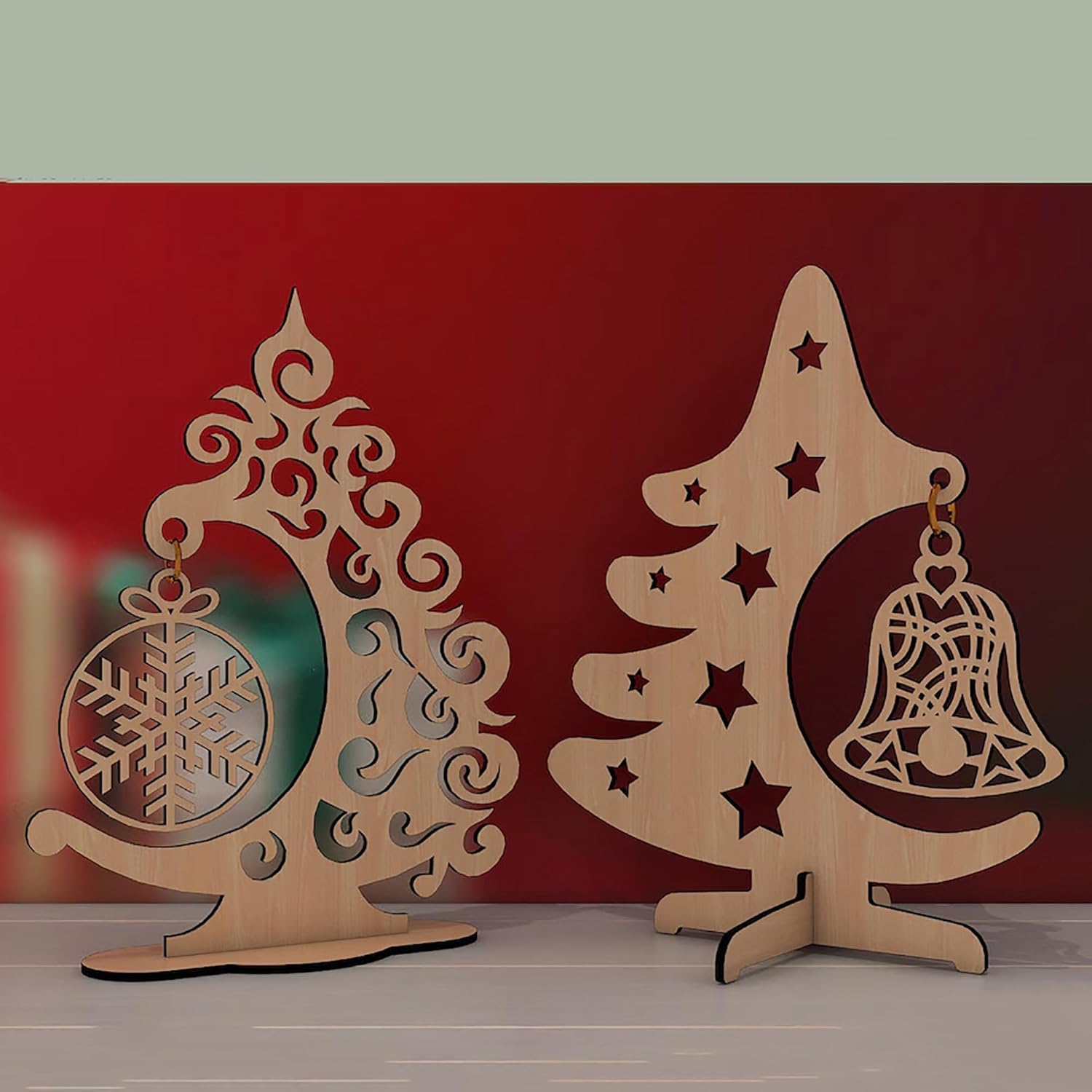 Two wooden Christmas tree decorations with intricate designs on a red background