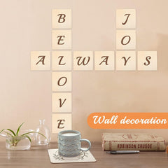 Wall decoration with wooden tiles spelling 'BE ALWAYS LOVE' on a beige wall, with a mug and books on a table below.
