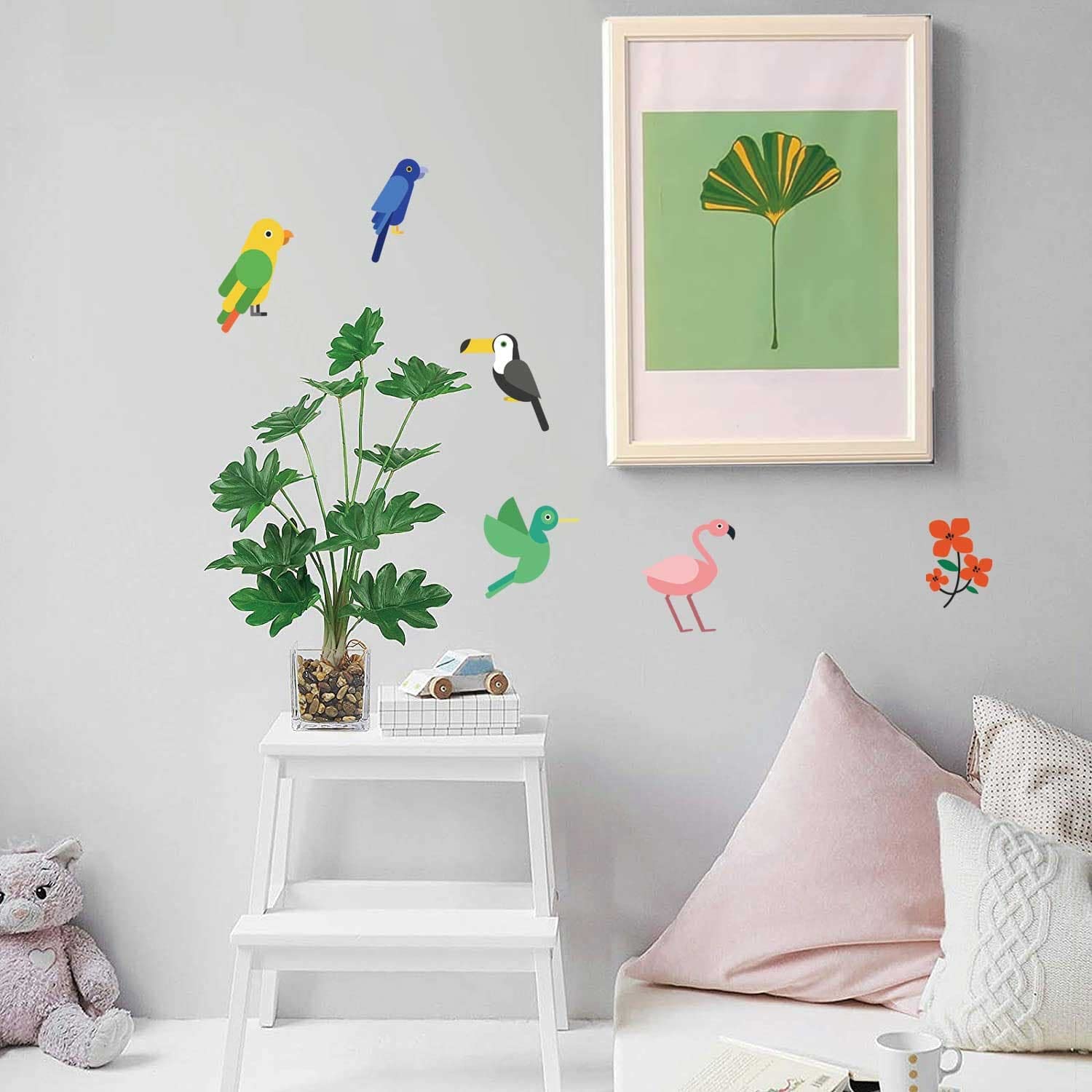 Children's room with wall decals of birds, plants, and flowers on a light gray wall.