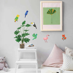 Children's room with wall decals of birds, plants, and flowers on a light gray wall.