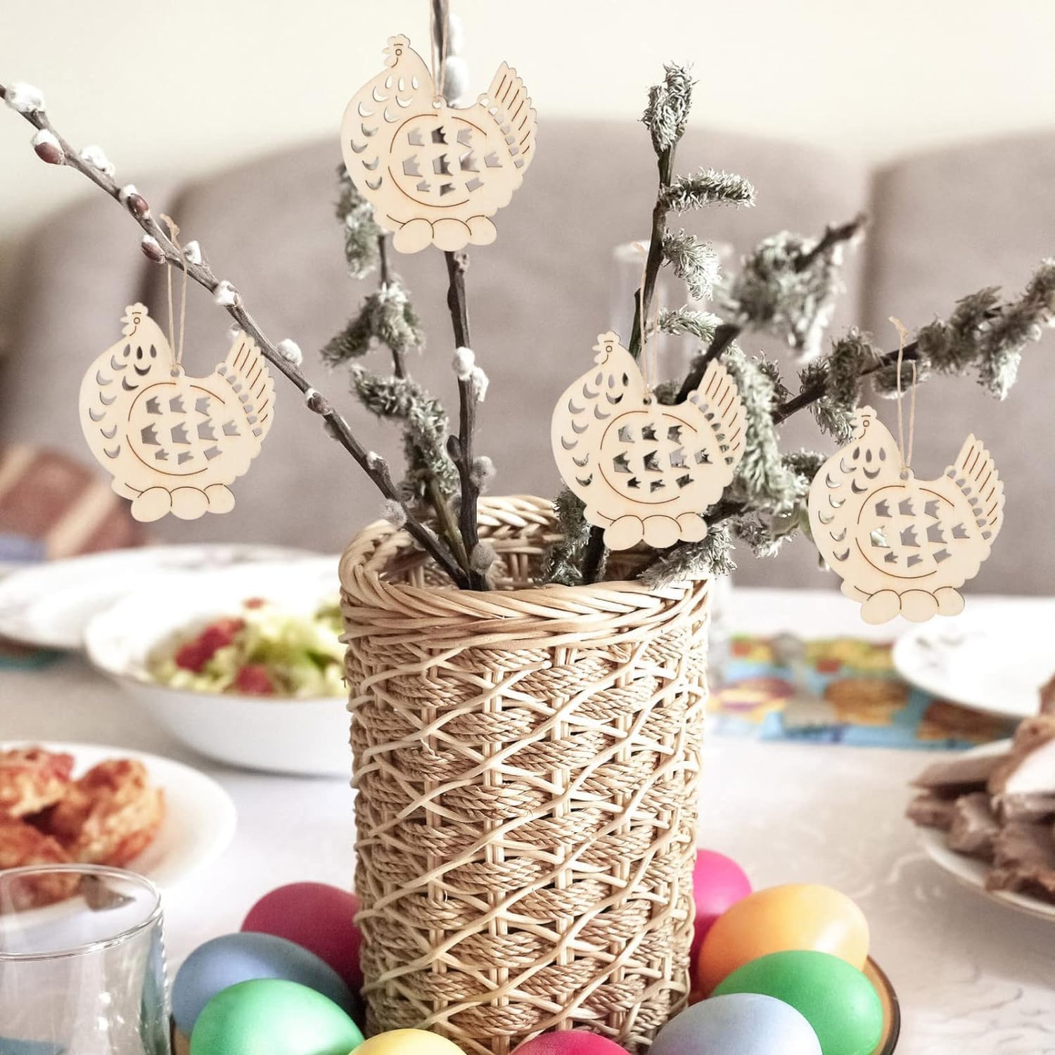Decorative Easter arrangement with wicker vase, branches, and colorful eggs on a table.