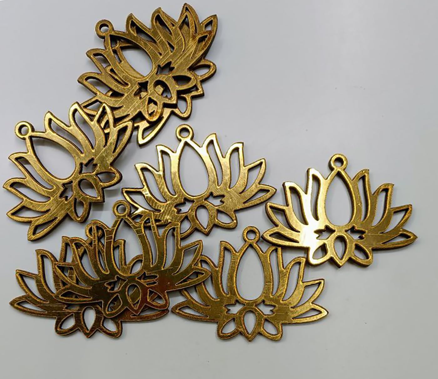 Gold lotus flower pendants on a gray background