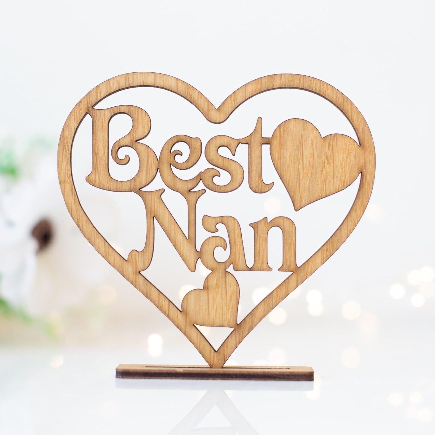 Wooden decorative item with 'Best Nan' text inside a heart shape on a white background