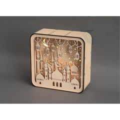 Wooden decorative box with cut-out designs and LED lights on a gray background