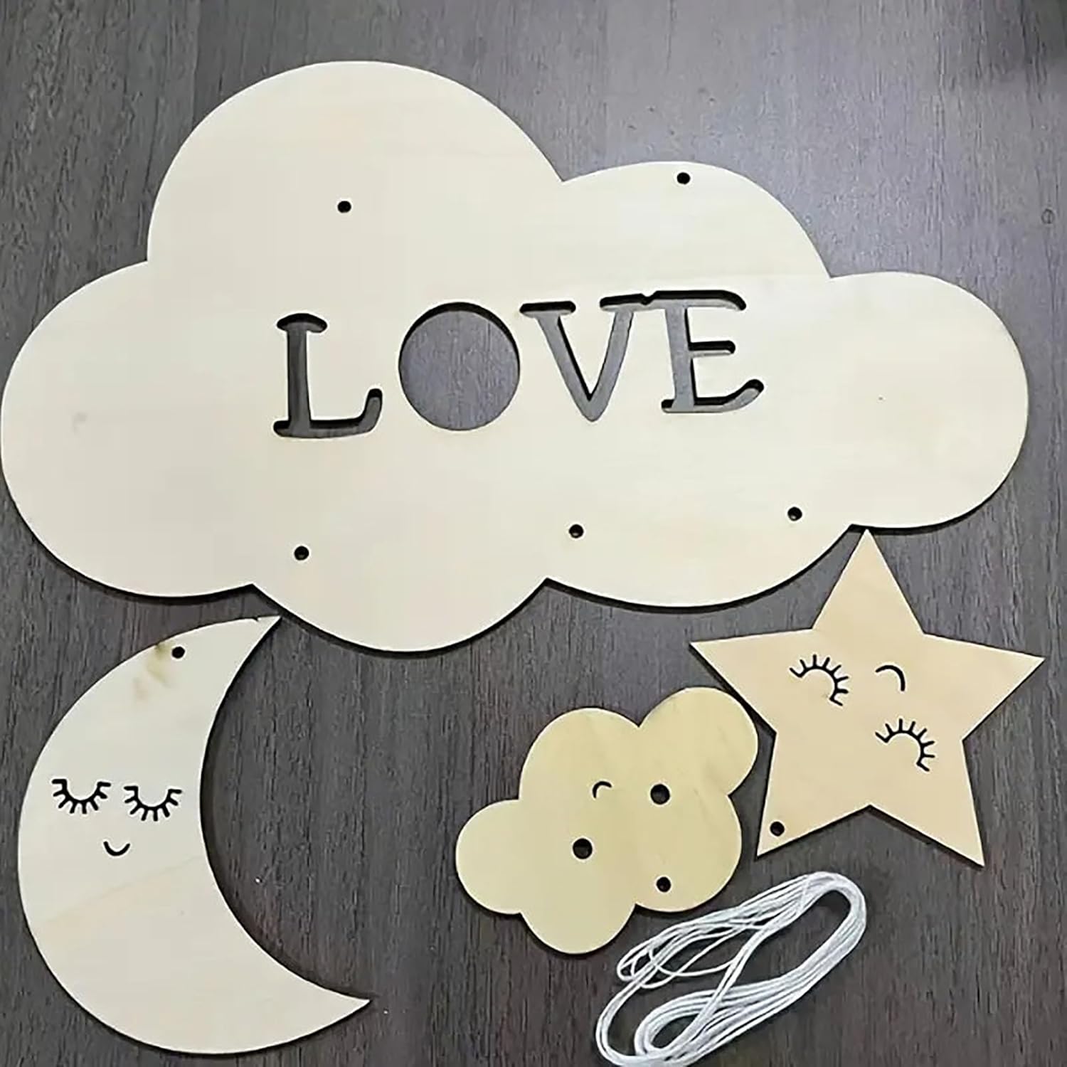 Decorative cloud with 'LOVE' letters, star, moon, and flower on a wooden surface.