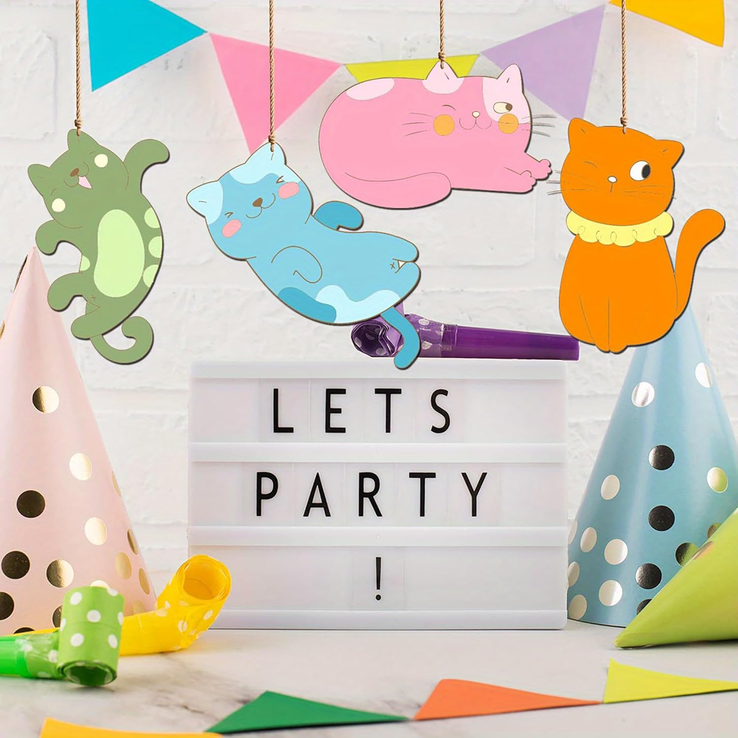 Decorative setup with colorful cat-shaped signs, party hats, and a 'LET'S PARTY!' sign.