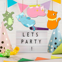 Decorative setup with colorful cat-shaped signs, party hats, and a 'LET'S PARTY!' sign.
