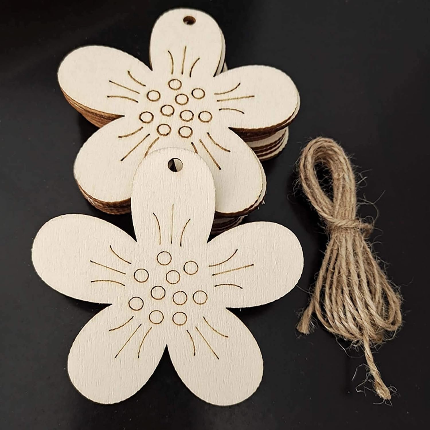 Wooden flower-shaped tags with jute string on a black background