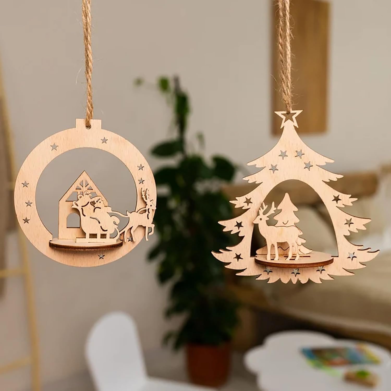 Two wooden Christmas tree decorations hanging against a neutral background