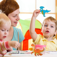 Woman and two children in a classroom setting with colorful dinosaur toys.