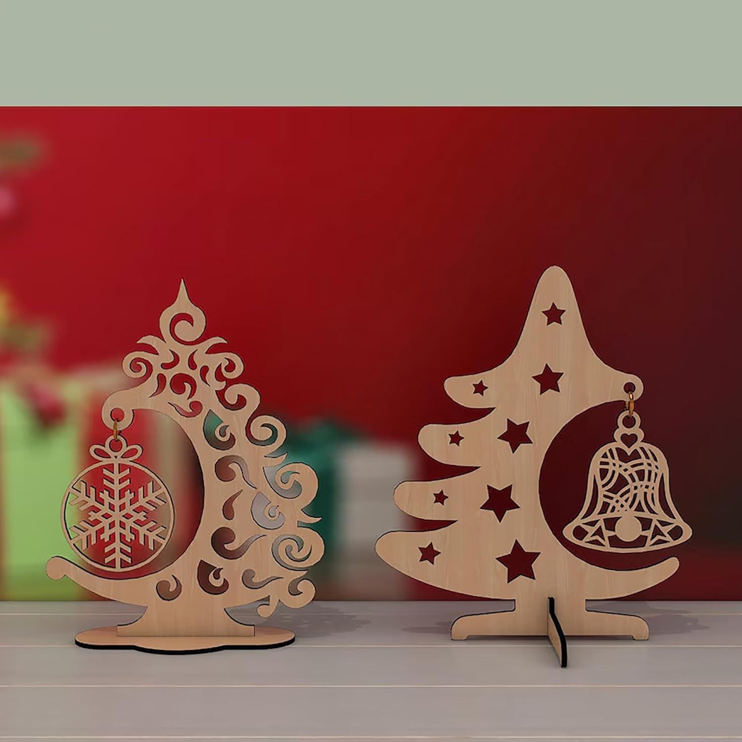 Two wooden Christmas tree decorations with bells and snowflakes on a red background