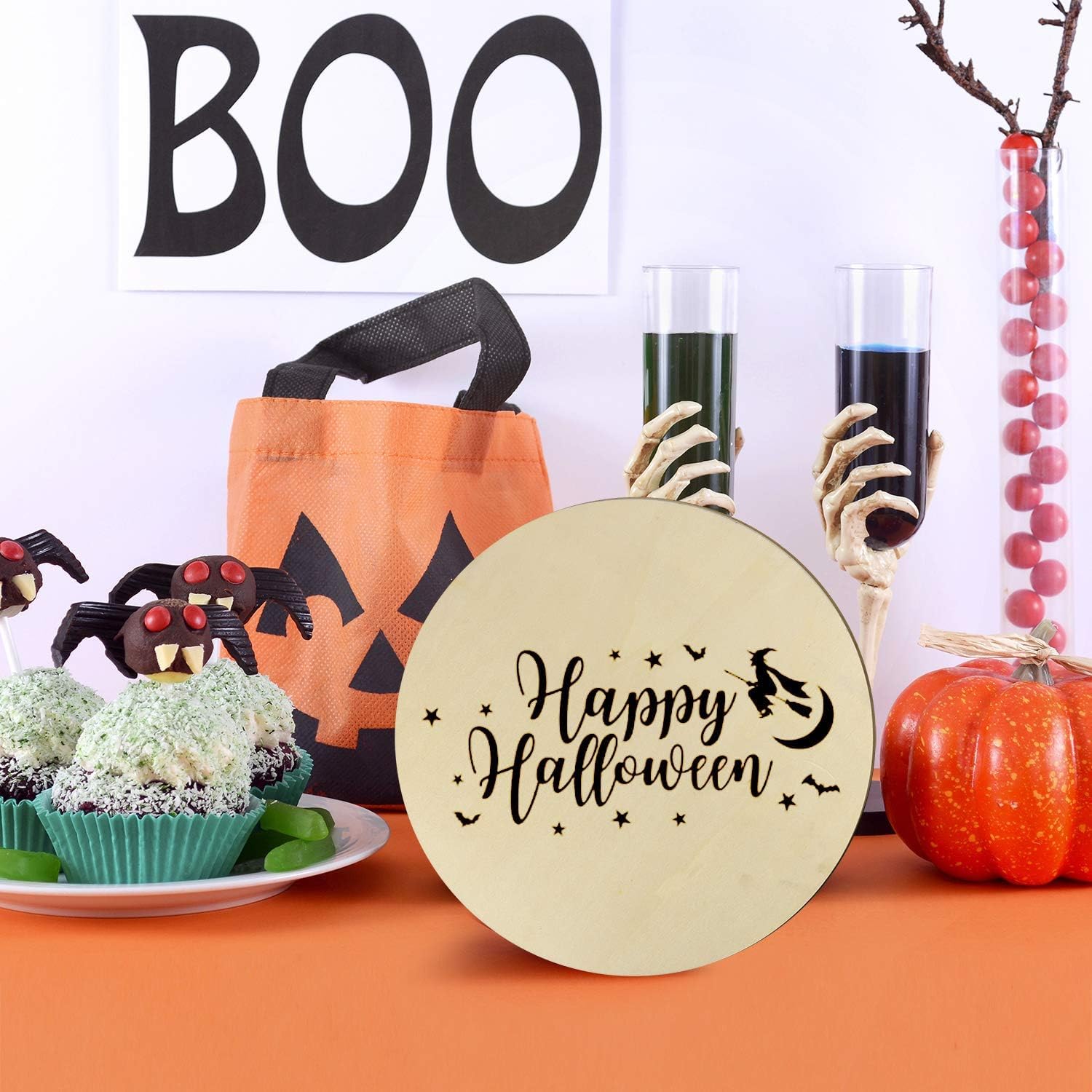 Halloween-themed table setting with 'Happy Halloween' sign, pumpkin, and candy.