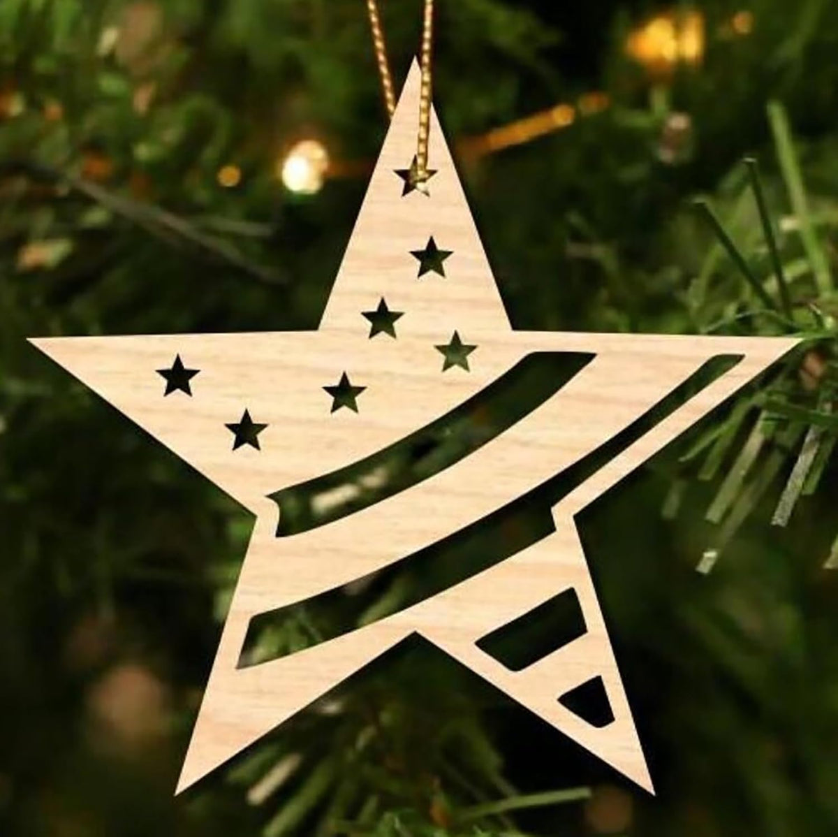 Wooden star-shaped ornament with cut-out stars on a Christmas tree.