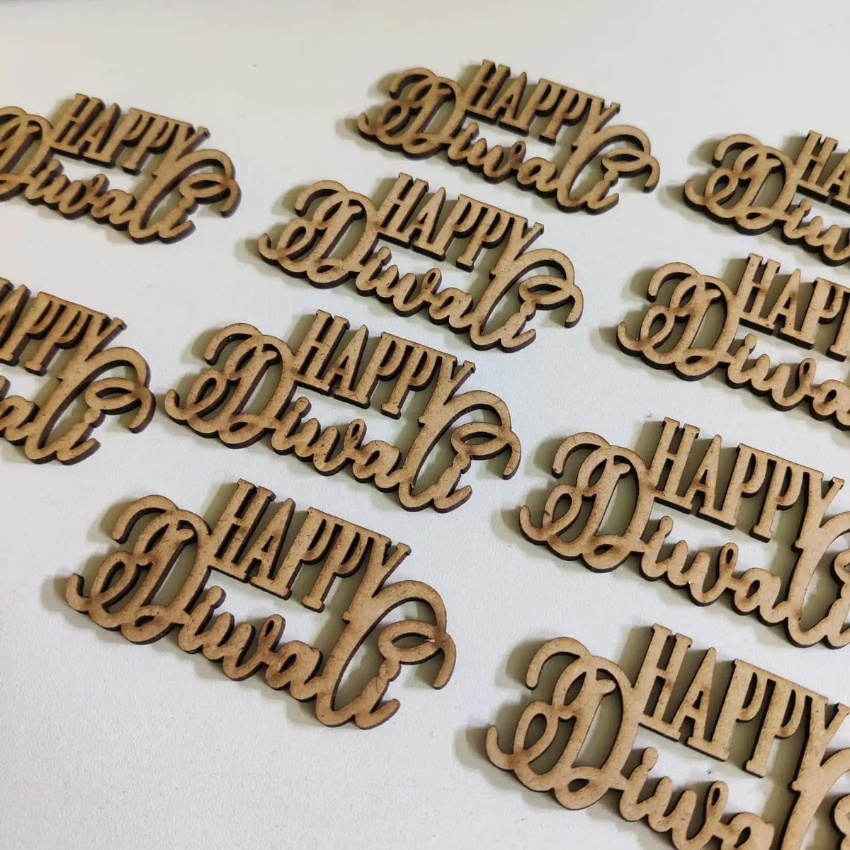 Wooden cutouts with 'Happy Diwali' text on a white background