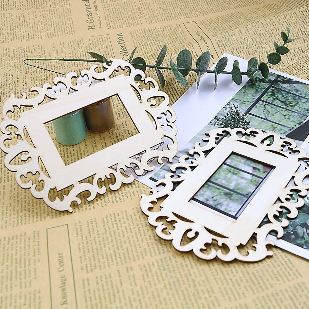 Two white decorative picture frames on a textured surface with greenery.