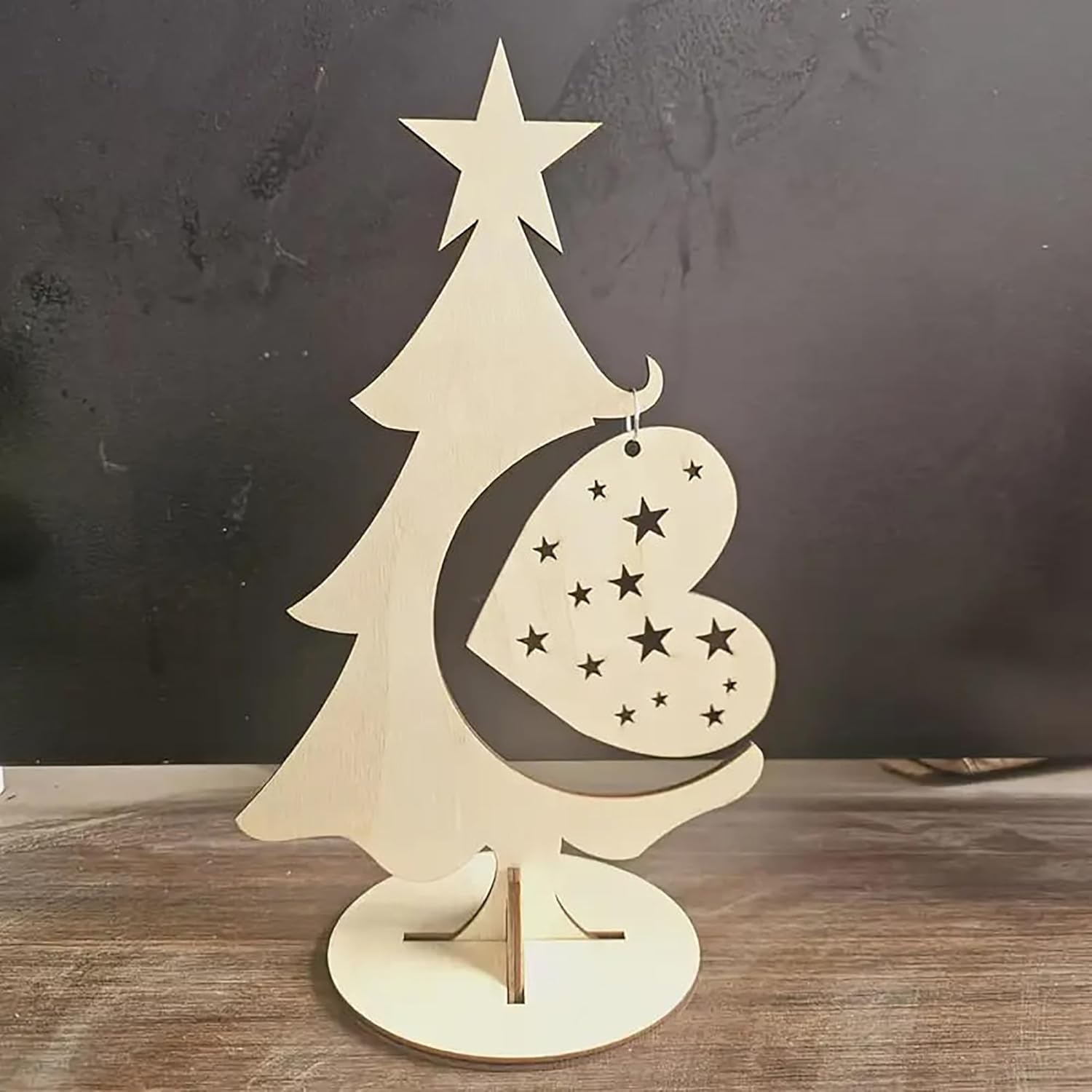 Wooden Christmas tree decoration with a heart ornament and star on a dark background