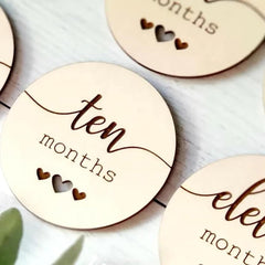 Wooden circular markers with text indicating months on a light background
