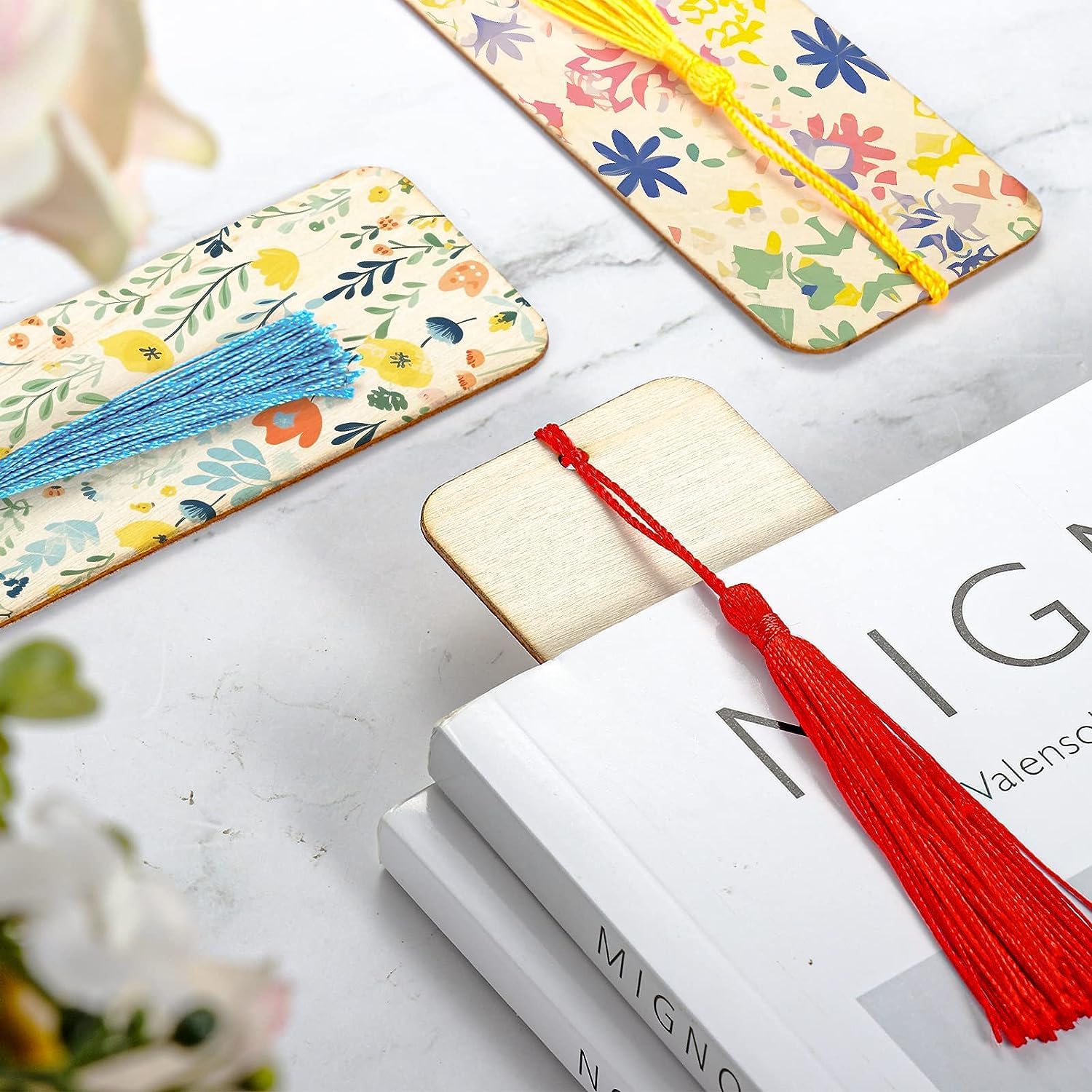 Floral bookmarks with tassels on a white surface