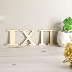 Decorative wooden letters on a wooden surface with a plant in the background