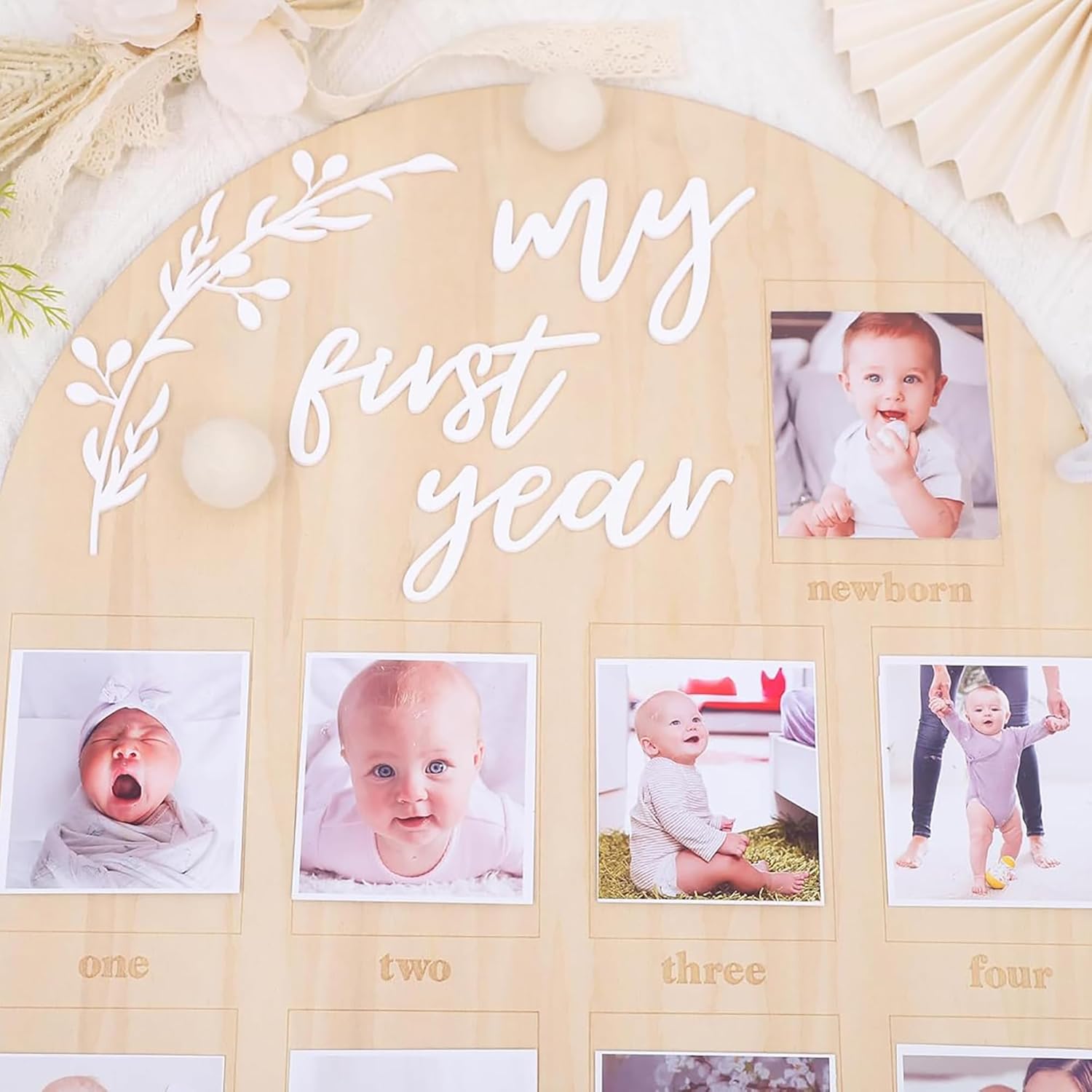 Wooden photo display with 'my first year' text and baby photos.